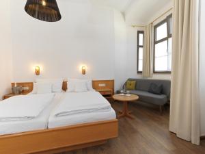 劳茵戈恩德瑞穆罕兰德娜酒店的一间卧室配有一张大床和一张沙发