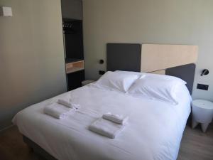 里尔Le Chat Qui Dort - Vieux Lille III的卧室配有白色的床和2条毛巾