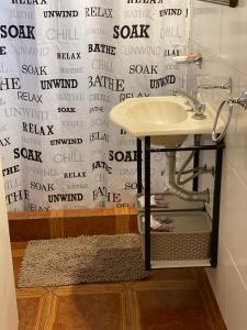 Muñizcasa Muñiz的一间带水槽的浴室和一个带写字台的墙壁