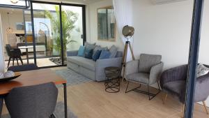 圣罗克Home at Azores - Oasis House的客厅配有沙发、两把椅子和一张桌子