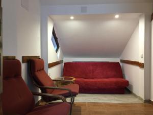 布拉索夫Pension Green Park的一个带两把椅子的房间的红色沙发