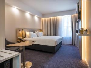 尼斯Holiday Inn Express - Nice - Grand Arenas, an IHG Hotel的酒店客房配有一张床铺和一张桌子。