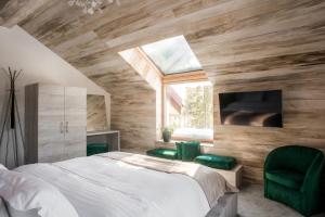 欧巴西亚洛德洛伊Sidharta Resort的一间卧室配有一张床和两张绿色椅子