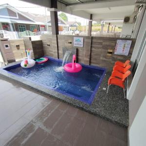 马六甲D'Q Putra Homestay Melaka (Unit AMAR)的一座小型游泳池,里面装有粉红色玩具