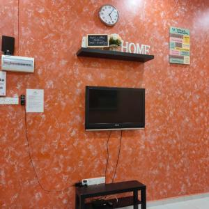 马六甲D'Q Putra Homestay Melaka (Unit AMAR)的墙上配有电视和时钟