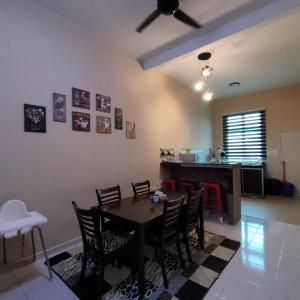 马六甲D'Q Putra Homestay Melaka (Unit AMAR)的一间带桌椅的用餐室和一间厨房