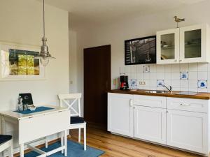 费马恩Kajüthus Apartment 1的厨房配有白色橱柜和水槽