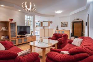 斯科普里Apartment Emilija的客厅配有2把红色椅子和桌子