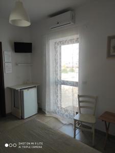 法萨诺Villa Lorenza的客房设有带椅子和书桌的窗户。
