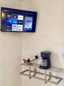 克雷尔HOTEL COLIBRÍ的墙上的电视,架子上设有咖啡壶