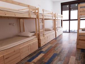塞维利亚Hub Hostel Seville的铺有木地板的客房内配有两张双层床。
