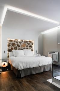 奥萨德蒙铁尔Mirador del Alba的一间卧室设有一张带石墙的大床