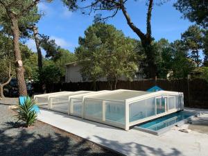 莱马特Les studios de l'Océan的一座玻璃房子,在院子里设有游泳池