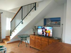 科尼尔-德拉弗龙特拉Apartamentos Los Olivos的客厅配有木梳妆台上的电视