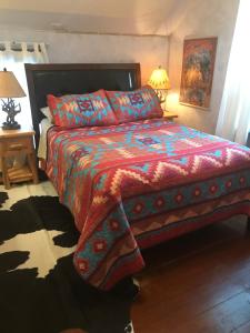 班夫住宿加早餐假日旅馆的一间卧室配有一张带五颜六色棉被的床