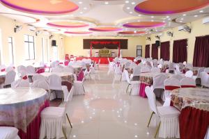Maruwā GhātHotel the Narayani的宴会厅配有白色的桌椅和舞台