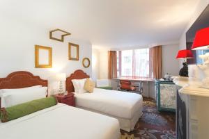 香港帝乐文娜公馆的酒店客房配有两张床和一张书桌