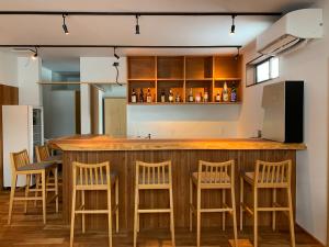 上越市やどバーTATSUJi的厨房设有带木凳的酒吧
