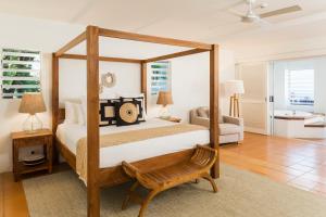 棕榈湾The Reef House Adults Retreat - Enjoy 21 Complimentary Inclusions的一间卧室配有木制天蓬床和沙发