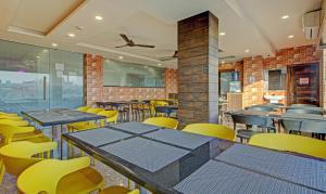 贾姆谢德布尔Treebo Trend Golden Heights的用餐室配有桌子和黄色椅子