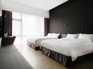 花莲市玫瑰香榭饭店的酒店客房设有两张床和大窗户。
