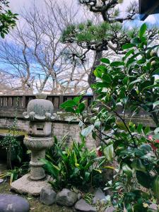 别府Guesthouse Sakichi的围栏前花园中的石雕