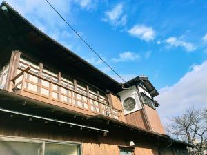 别府Guesthouse Sakichi的建筑的侧面有时钟