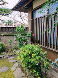 别府Guesthouse Sakichi的花园旁带围栏的门廊