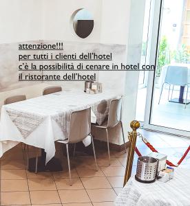 基瓦索城市酒店的一间配备有白色桌椅的用餐室