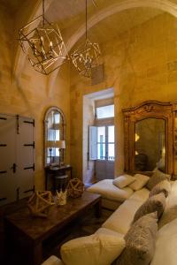 维洛里奥萨Palazzino Birgu Host Family Bed and Breakfast的一间带两张床和镜子的客厅