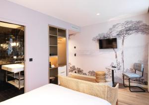 巴黎Le Katorze Hôtel的卧室配有一张床,墙上配有电视。