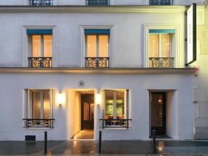 巴黎Le Katorze Hôtel的白色的建筑,设有窗户和阳台