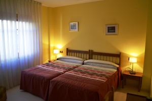 乌铁尔贝加诺旅馆的一间卧室配有一张大床和两盏灯