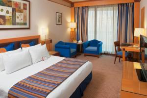 贝鲁特哈姆拉贝鲁特皇冠假日酒店的酒店客房,配有一张床、一张桌子和椅子