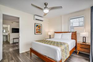 檀香山Aloha Suites Waikiki的一间卧室配有一张床和吊扇