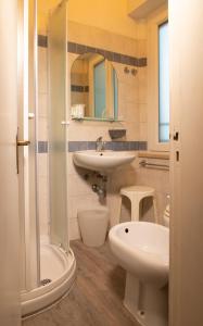 里乔内Hotel Arlecchino Riccione的一间带水槽、卫生间和淋浴的浴室