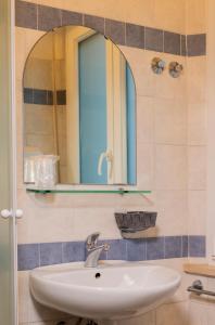 里乔内Hotel Arlecchino Riccione的一间带水槽和镜子的浴室