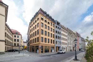 德累斯顿Modernes Apartment am Neumarkt的街道上的建筑物,前面有停车位