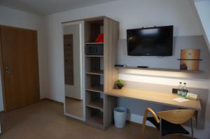诺伊霍夫安德泽恩Zenntaler Hof的客房设有书桌和墙上的电视