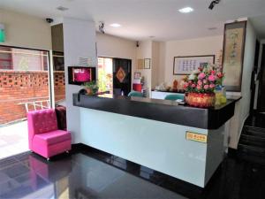 新加坡SENG WAH HOTEL的大堂设有酒吧,配有粉红色的椅子