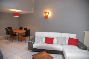 凯泽贝尔Le cerisier的客厅配有带红色枕头的白色沙发