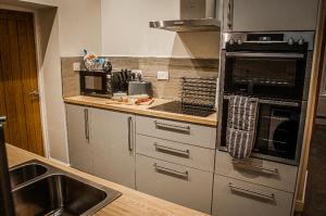 考文垂Log cabin的厨房配有不锈钢用具和水槽