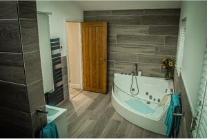 考文垂Log cabin的客房内的浴室设有大浴缸