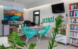 卡门港Apartamentos La Tegala的办公室配有书桌和2把蓝色椅子