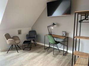 汉诺威Aparthotel Charlotten的一间带椅子、书桌和电视的房间