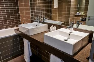 曼彻斯特曼彻斯特市中心皇冠假日酒店的浴室配有两个盥洗盆和浴缸。