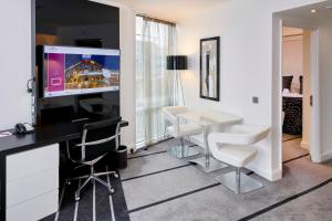 曼彻斯特曼彻斯特市中心皇冠假日酒店的配有桌椅和电视的客房