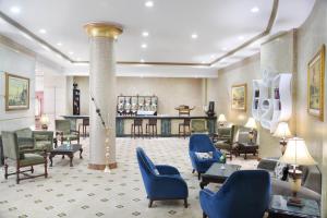 阿斯旺Tolip Aswan Hotel的大堂设有蓝色椅子和柱子