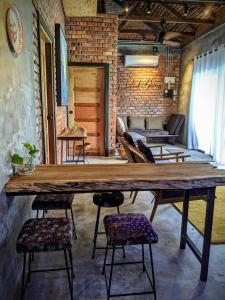 珍南海滩Rumah Bendang Langkawi Villa Pool的配有椅子的房间里一张大木桌