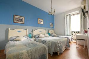 马德里马德里瓦伦西亚旅馆的一间卧室设有两张带蓝色墙壁的床